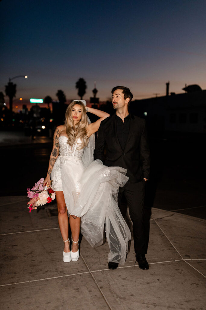 Couple flash vintage Las Vegas wedding photos on Fremont Street