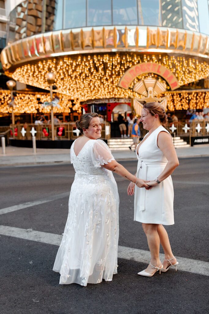 Couple walking on Fremont Street for their LGBTQ+ downtown Las Vegas wedding photos