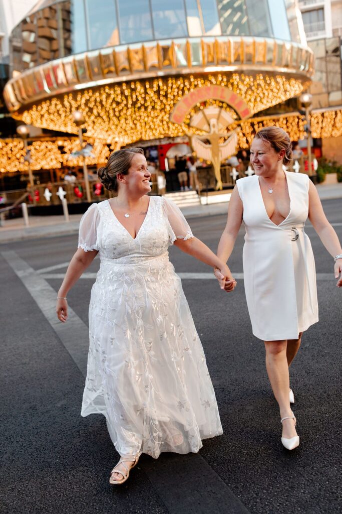 Couple walking on Fremont Street for their LGBTQ+ downtown Las Vegas wedding photos