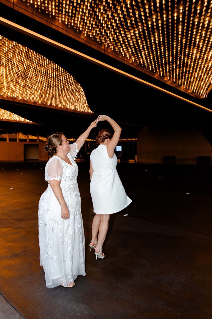 Woman twirling her partner around during their downtown Las Vegas wedding photos on Fremont Street