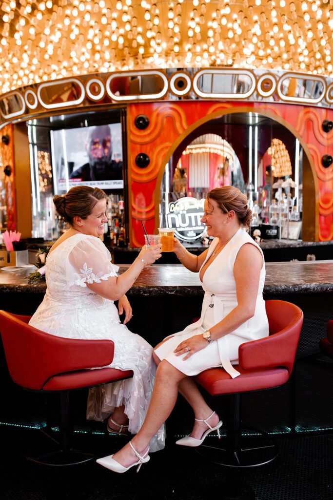 Couple cheering their drinks during their downtown Las Vegas wedding photos at Carousel Bar