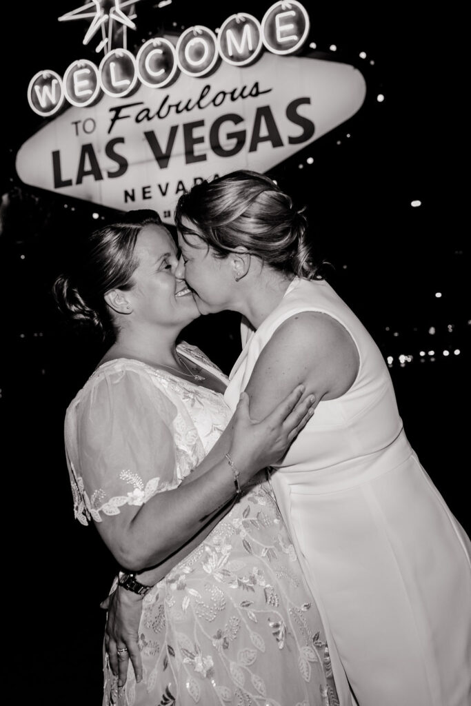 Black and white photo of a couple kissing during their downtown Las Vegas wedding photos at night