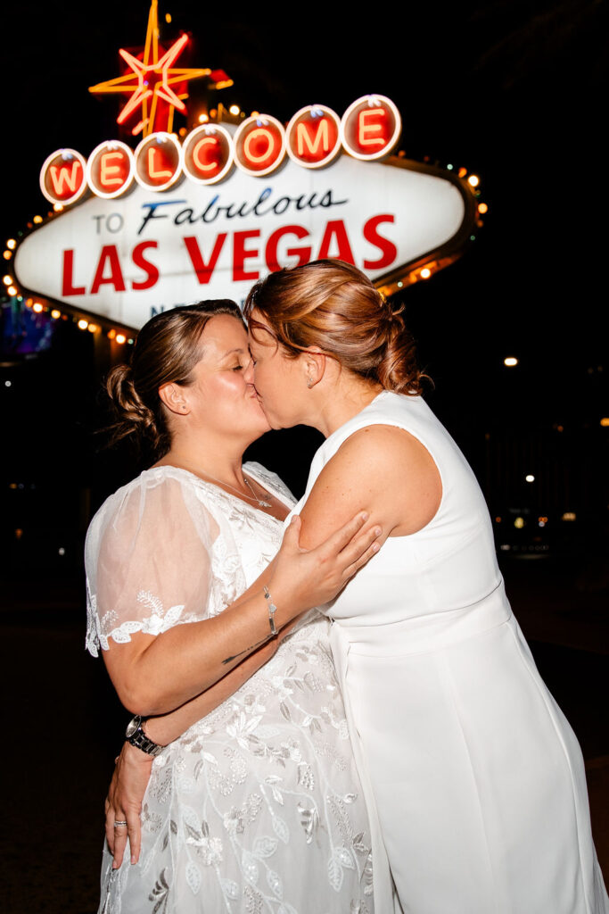 Couple kissing during their downtown Las Vegas wedding photos at night