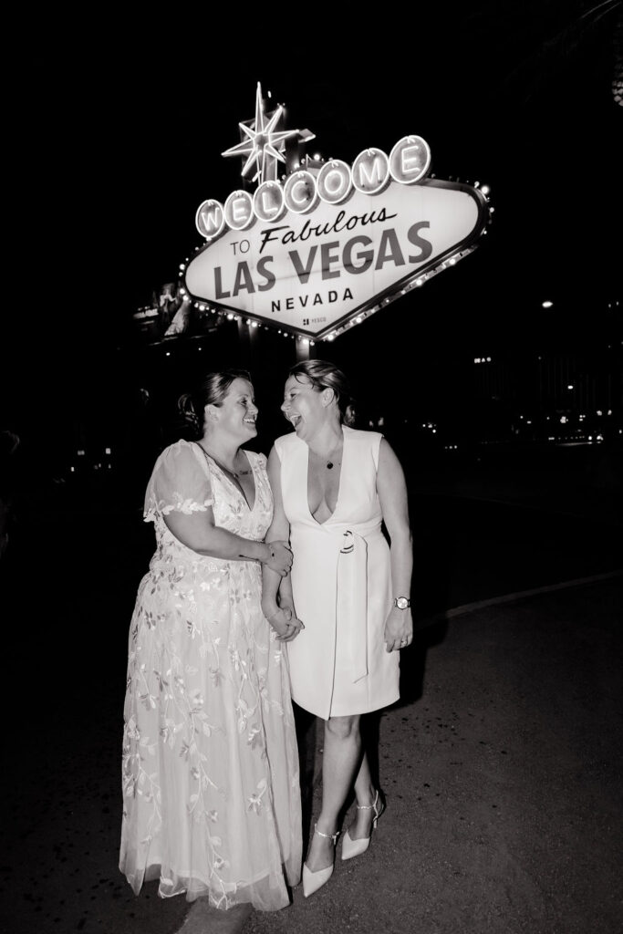 Black and white photo of a couple posing in front of the Welcome to Fabulous Las Vegas sign