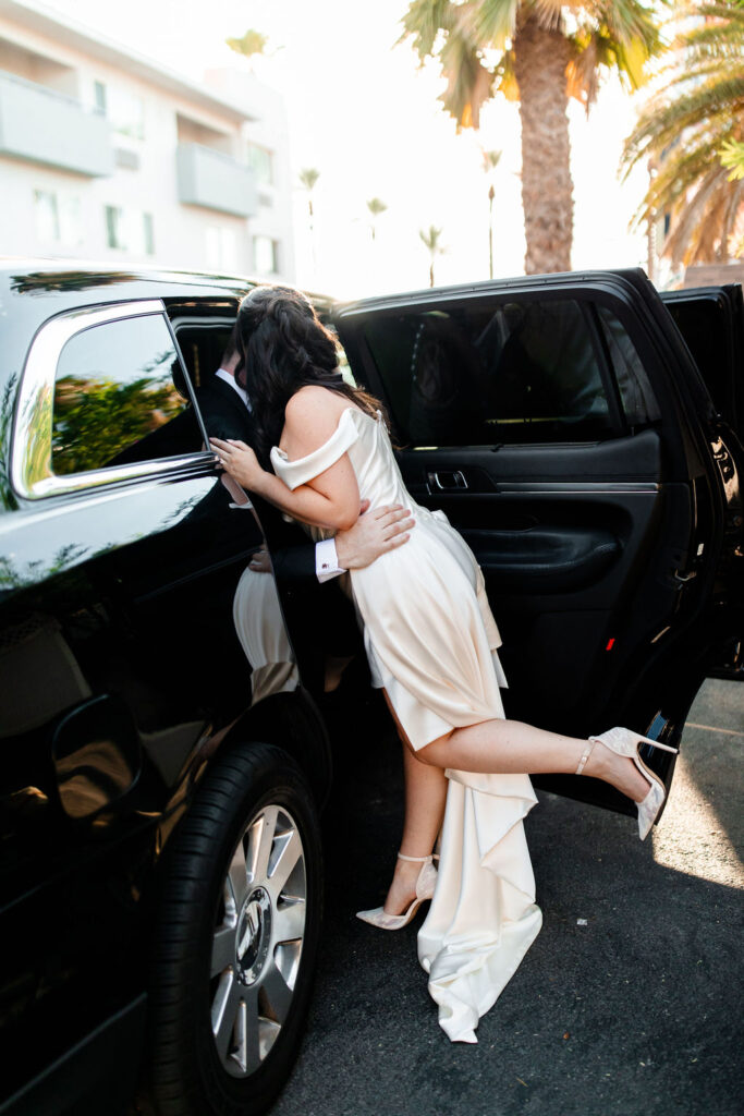 Couple kissing by their limo during their Las Vegas wedding portraits