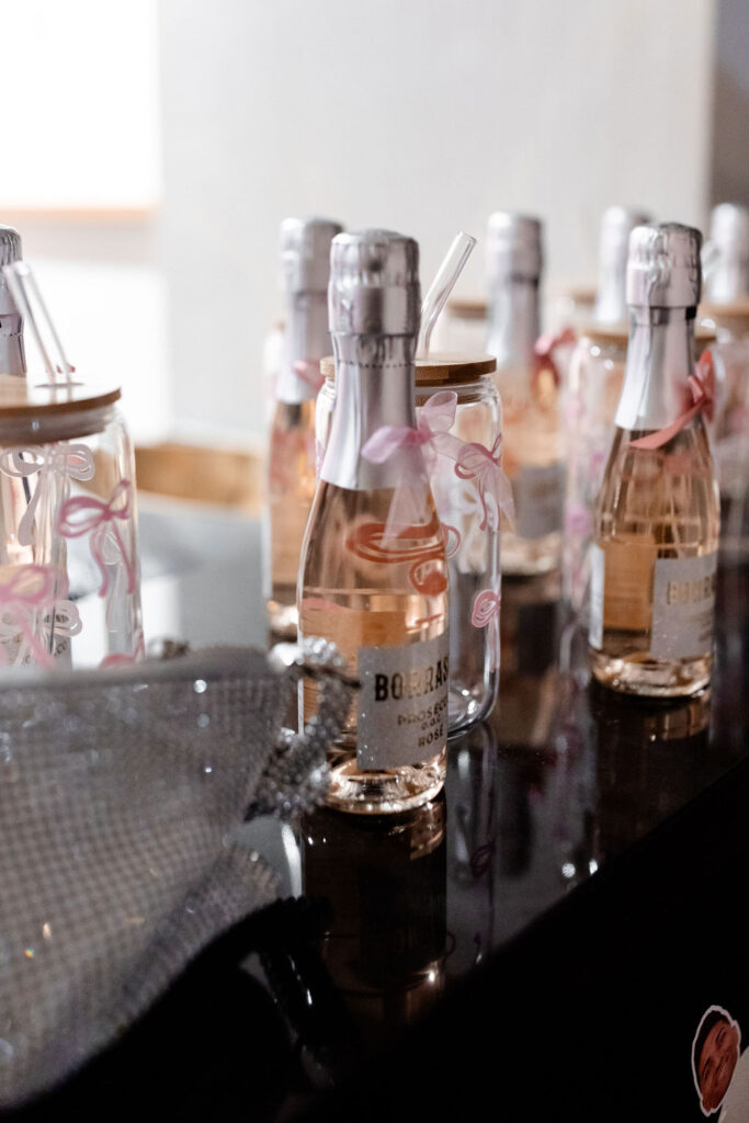 Mini prosecco bottles with pink bows for a classy Las Vegas bachelorette toast

