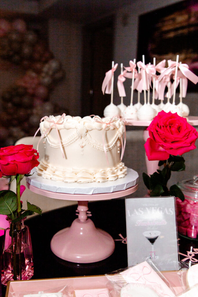 Elegant dessert setup with bow-topped cake and roses at a Las Vegas bachelorette party