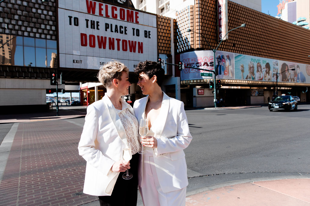 LGBTQ+ couple posing on Fremont Street for their downtown wedding photos