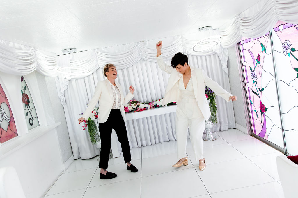 LGBTQ+ couple having fun and dancing after their Little White Wedding Chapel elopement