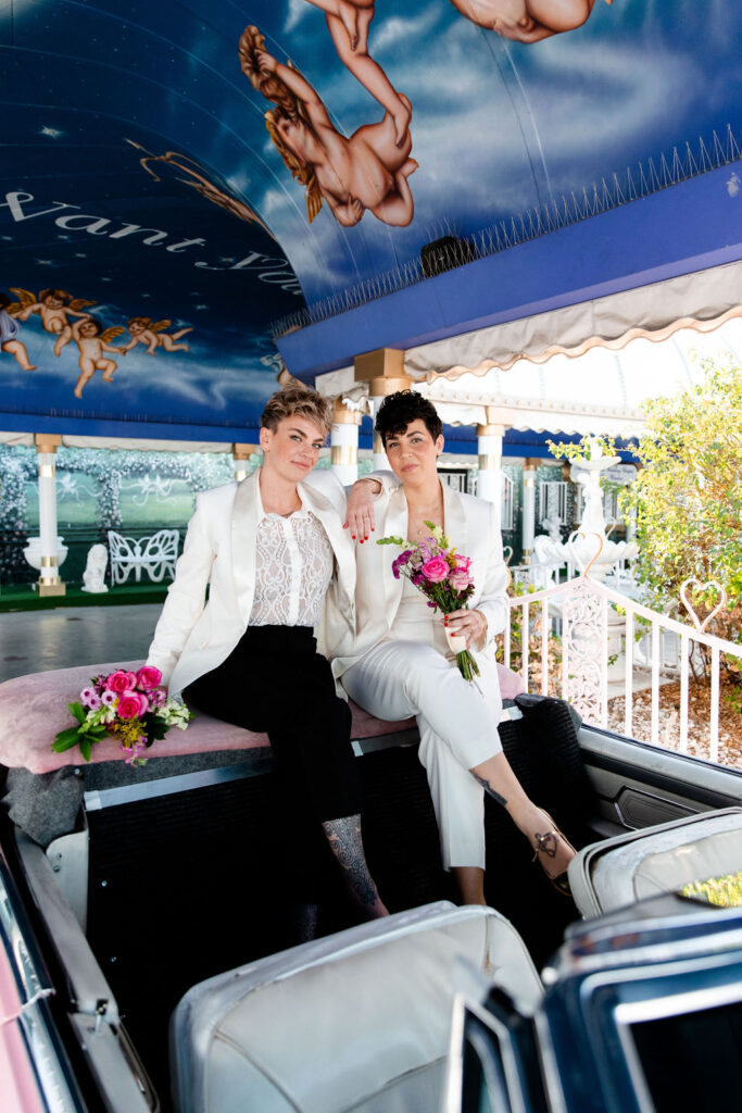 LGBTQ+ wedding photos in the iconic Pink Cadillac at Little White Wedding Chapel in Las Vegas