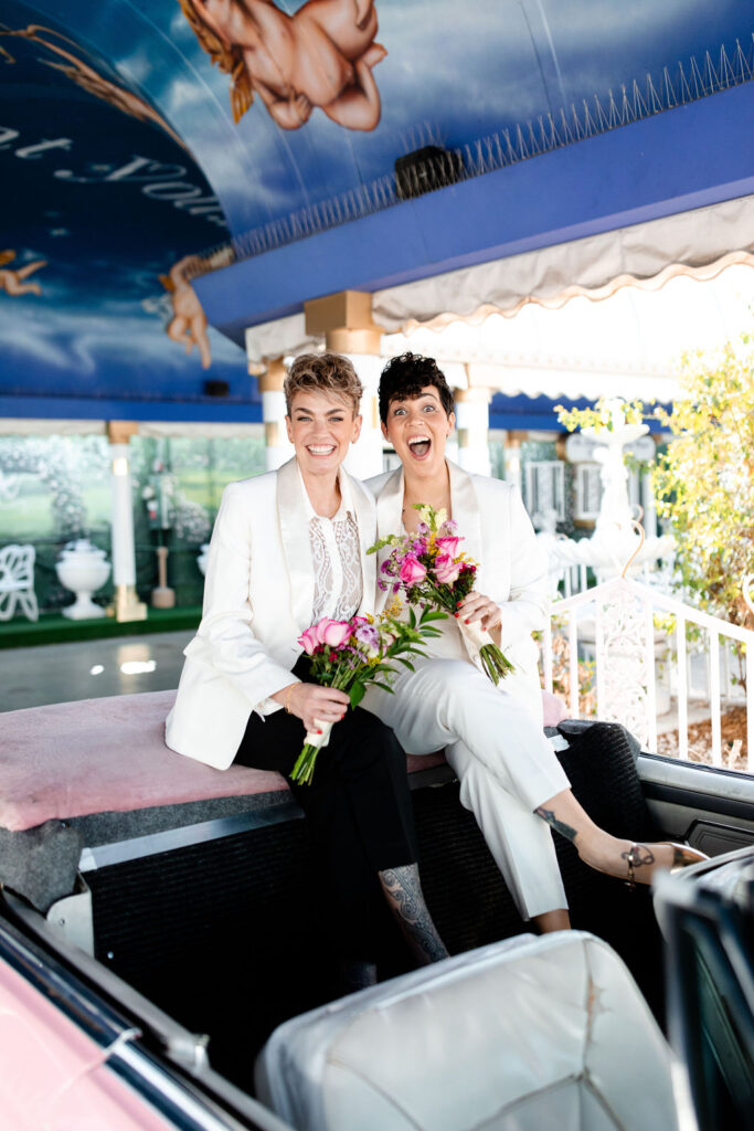 LGBTQ+ wedding photos in the iconic Pink Cadillac at Little White Wedding Chapel in Las Vegas