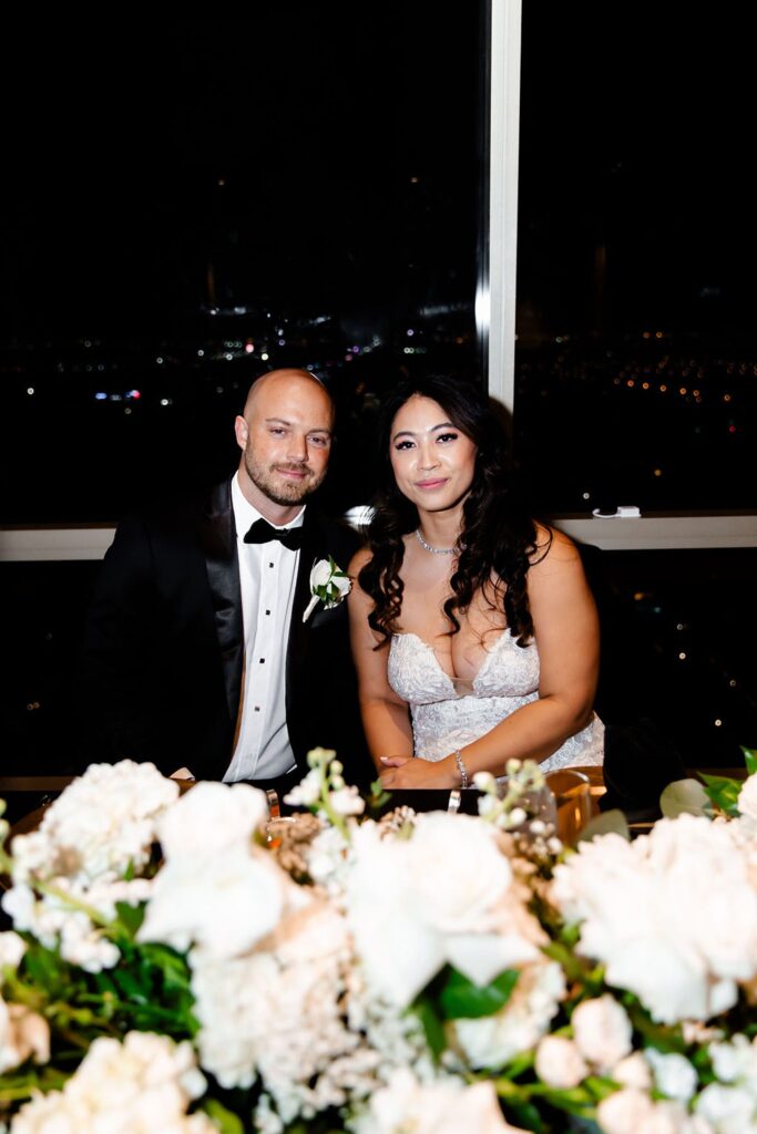 Bride and groom sitting at their sweethearts table during their Las Vegas wedding reception at Lux at The M Resort