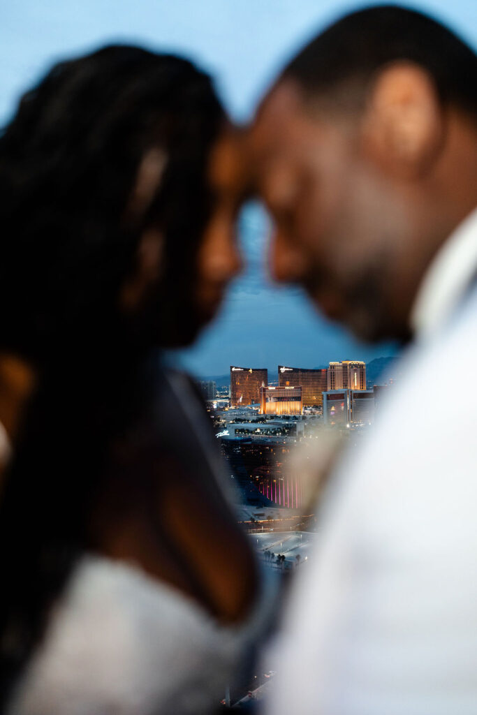 Bride and groom posing on a Las Vegas balcony at dusk