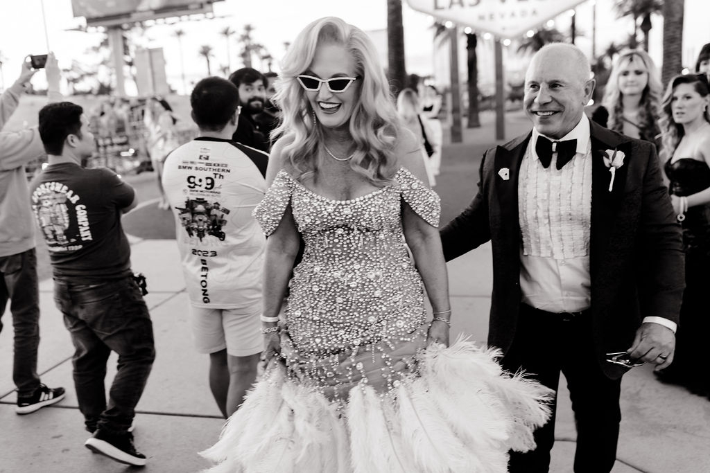 Black and white photo of a bride and groom in front of the the Welcome to Fabulous Las Vegas sign