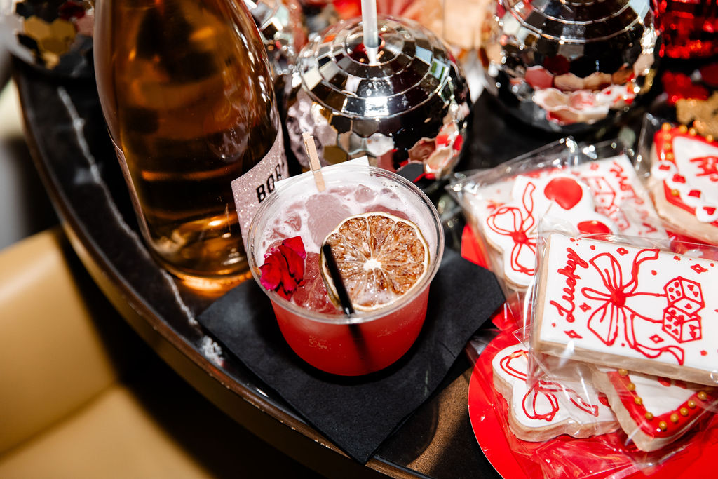Vegas bachelorette party theme setup with disco balls, custom cookies, and a signature Lucky in Love cocktail