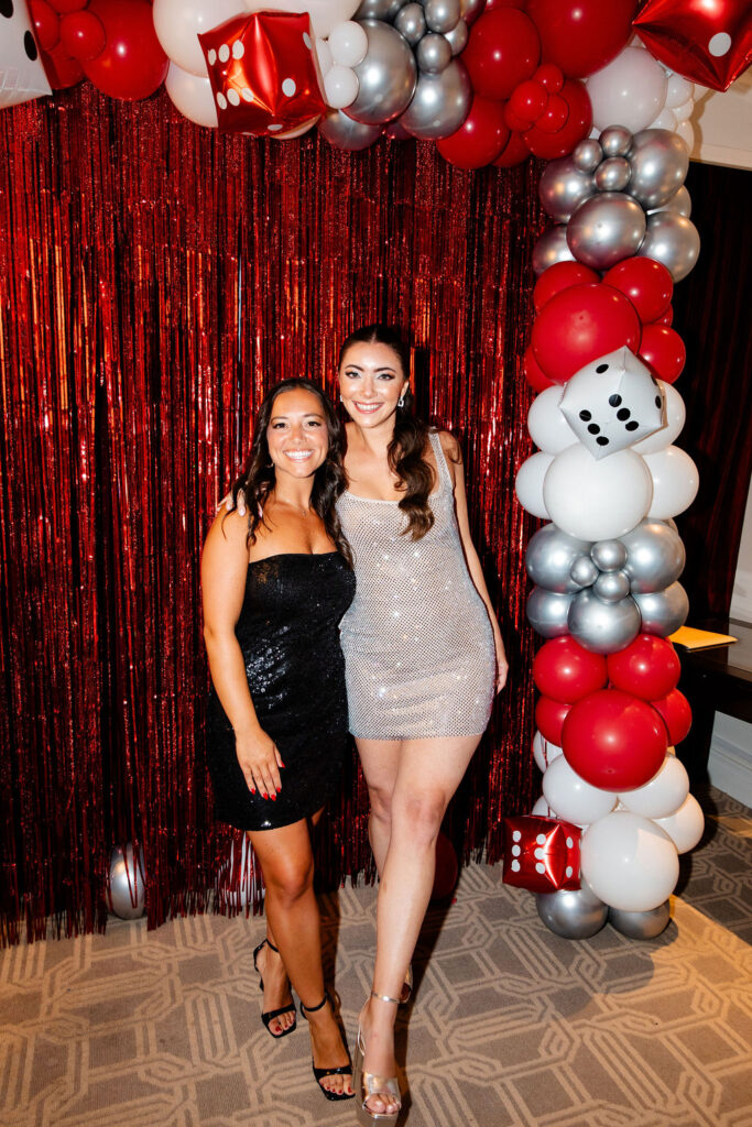 Bride in sparkly dress smiling with her friend in a strapless black dress at a Lucky in Love bachelorette party in Las Vegas