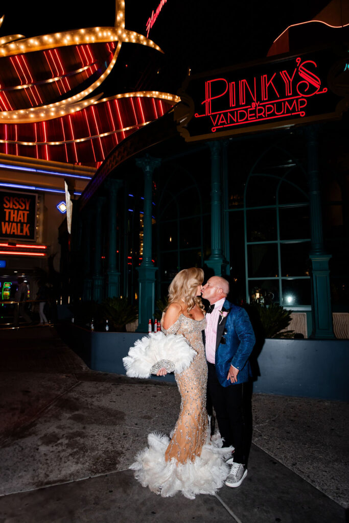 Couple sharing a kiss outside Pinky’s by Vanderpump in Las Vegas at night.