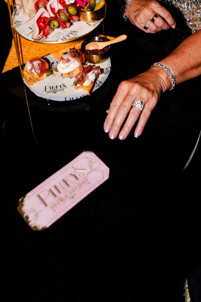 Elegant charcuterie and hors d’oeuvres on a tiered gold stand at Pinky’s Las Vegas wedding reception.