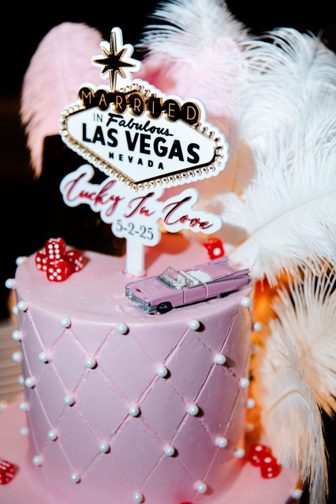 Pink Las Vegas wedding cake with custom wedding topper, dice, and a pink Cadillac