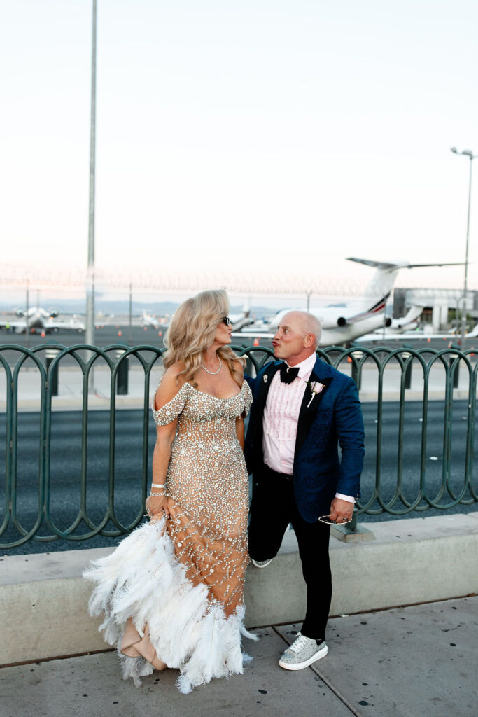 Bride and groom posing in front of Harry Reid International Airport for their wedding photos