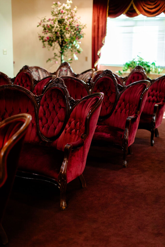 Red velvet seating inside Chapel Amore at The Little White Wedding Chapel