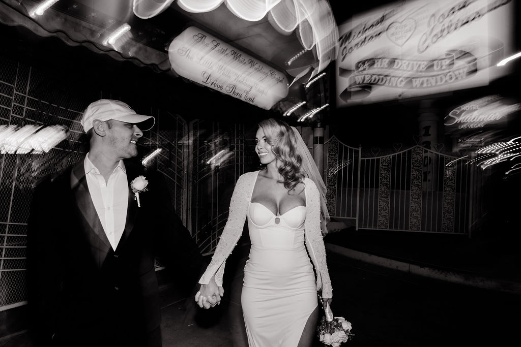 Black and white photo of a bride and groom posing for photos at The Little White Wedding Chapel in Las Vegas