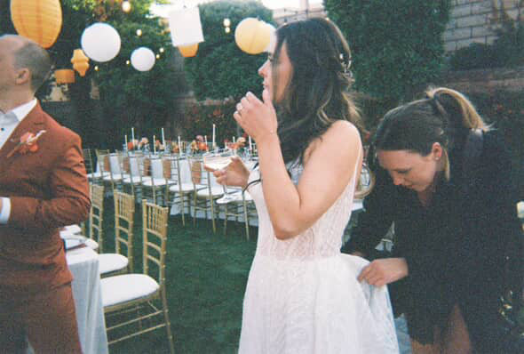Photographer adjusting the brides dress during her Mid Century Manor Las Vegas micro wedding reception