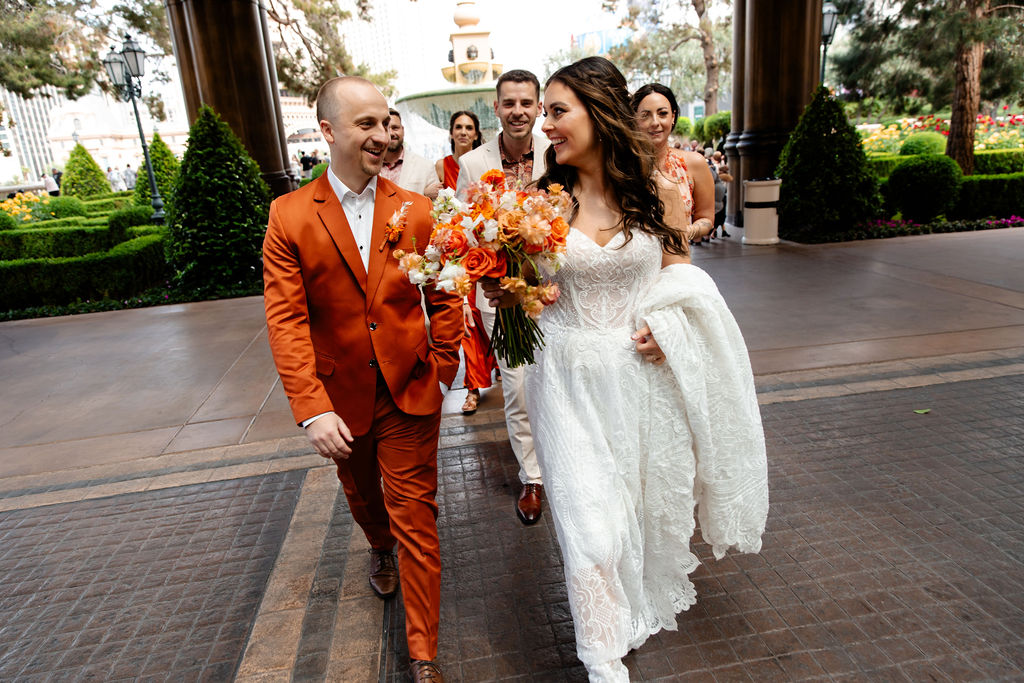 Bride, groom, and their wedding party walking into Bellagio for their Las Vegas micro wedding casino photos