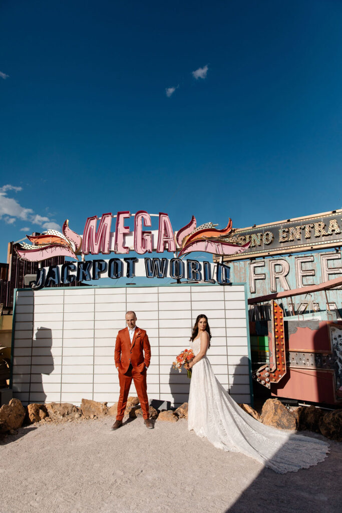 Editorial wedding portraits in front of the Mega Jackpot World sign at Neon Museum in Las Vegas