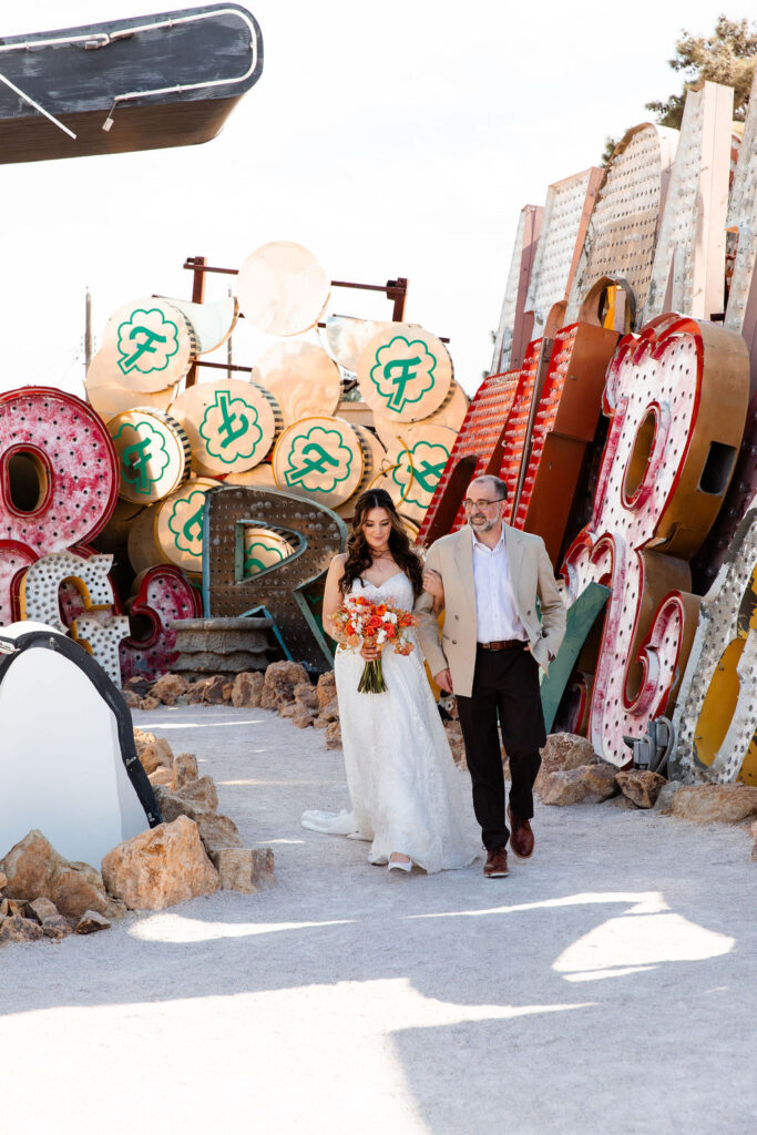 Bride being walked down the aisle by her father at Neon Museum