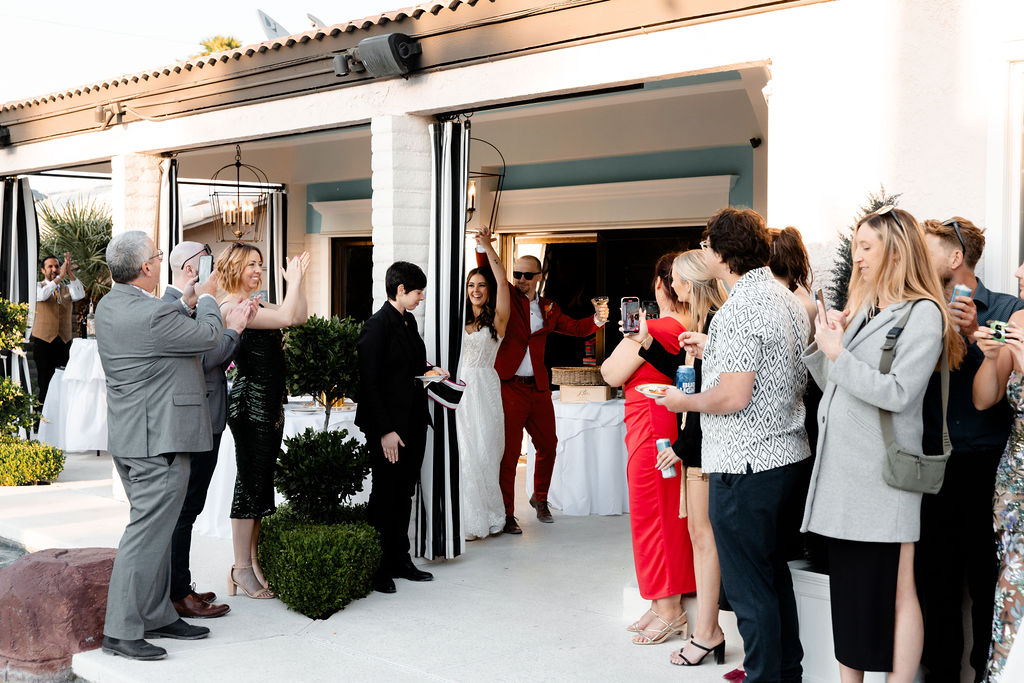 Couple entering their Las Vegas micro wedding reception, greeted by guests cheering and clapping
