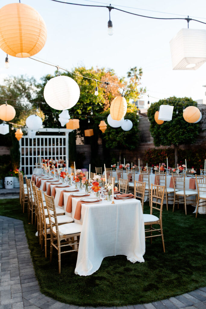 Outdoor reception tables decorated with lanterns and colorful florals at Mid Century Manor