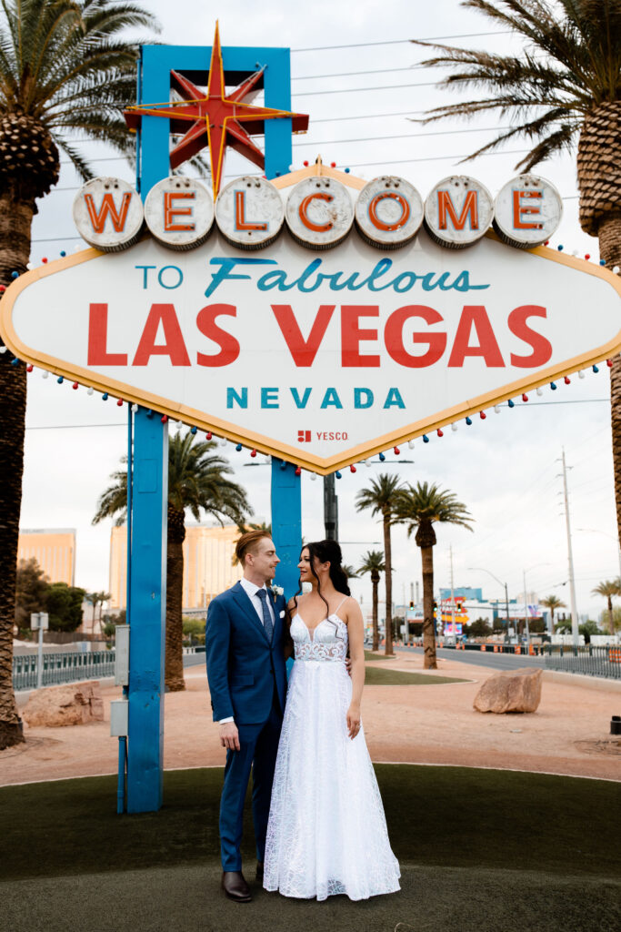 Bride and groom posing in front of the Welcome to Fabulous Las Vegas sign