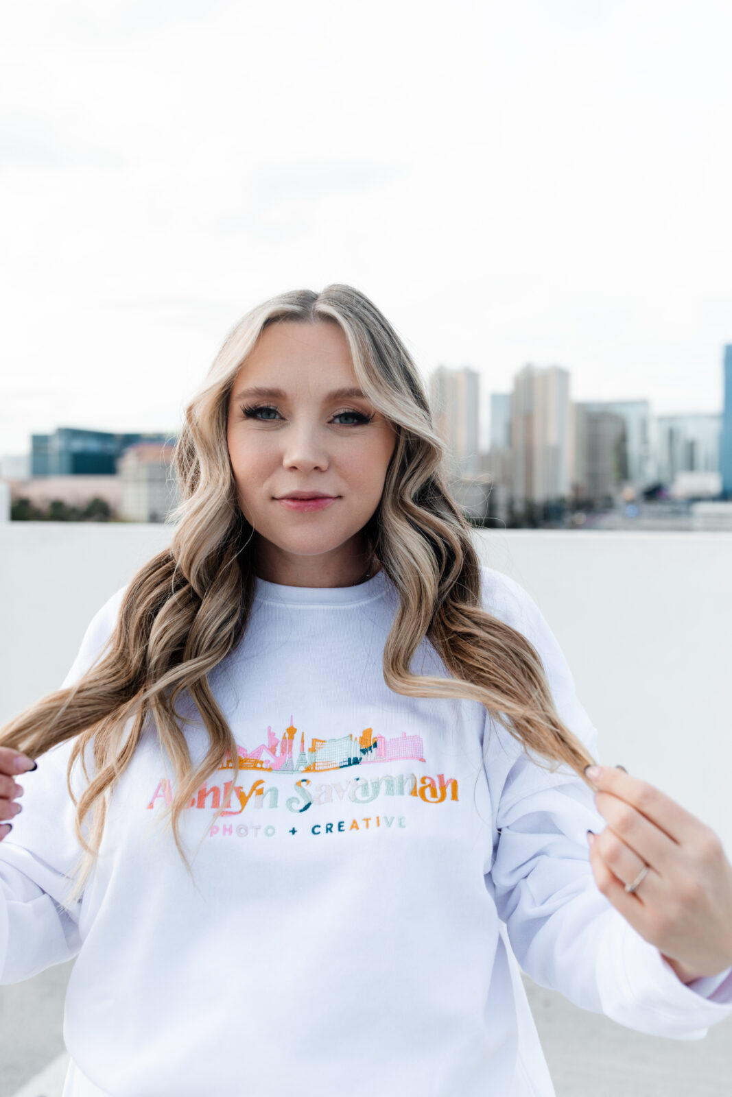 Ashlyn Savannah - a Las Vegas wedding and elopement photographer posing for her brand photos on a rooftop in Las Vegas