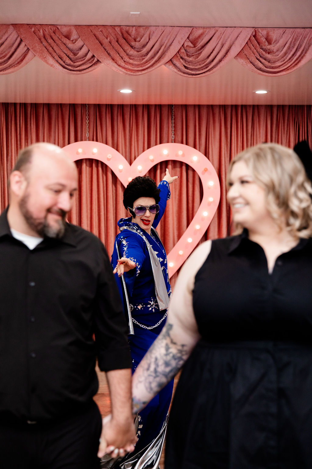 Couple walking back down the aisle as husband and wife with Lady Elvis in the background of their photo
