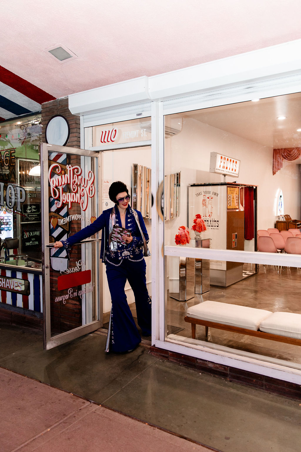 Lady Elvis holding the door open to welcome a couple into Sure Thing Chapel in Las Vegas