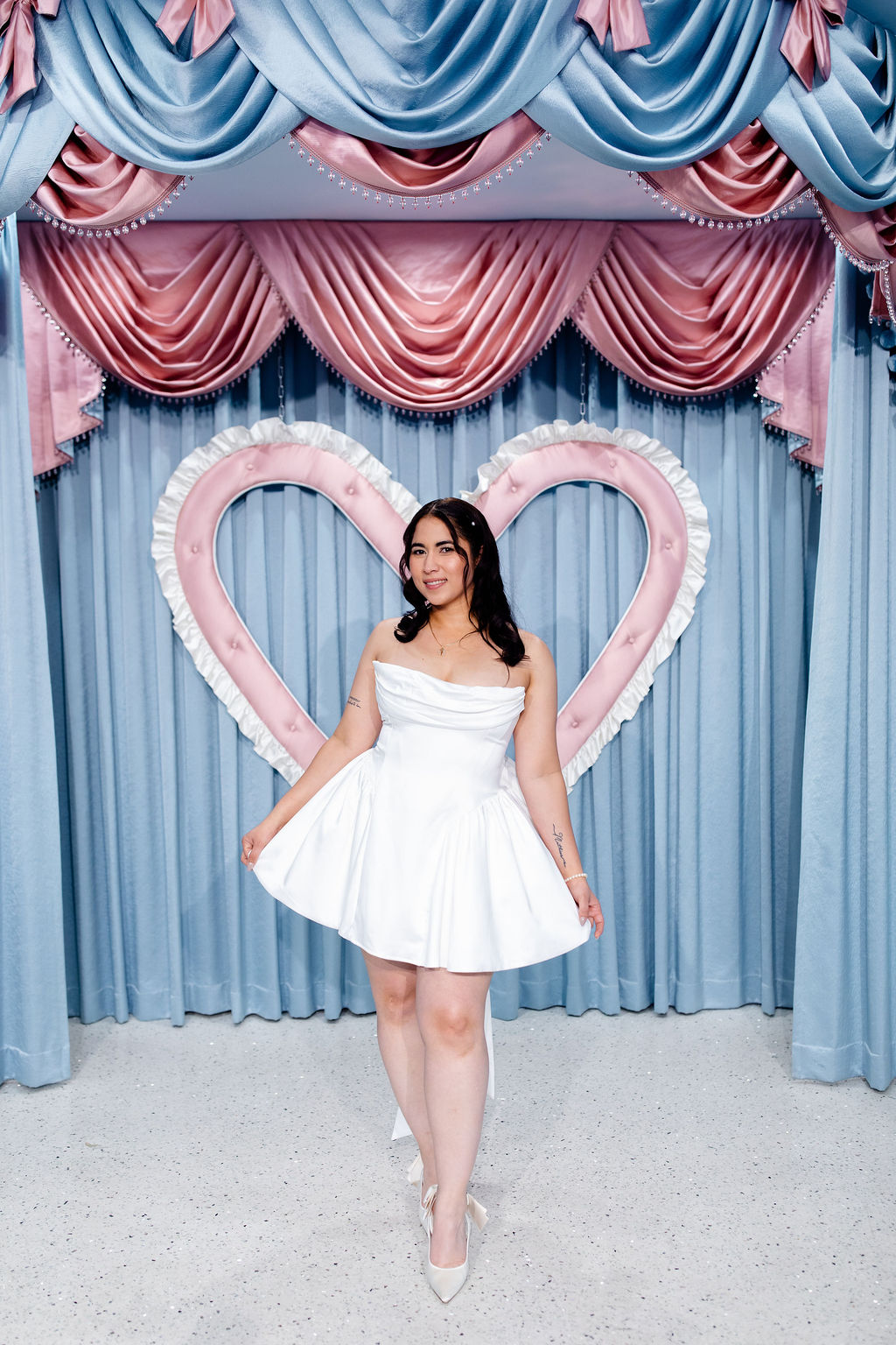 Bride posing in front of the baby blue and pink ceremony setup at Sure Thing Too in Las Vegas