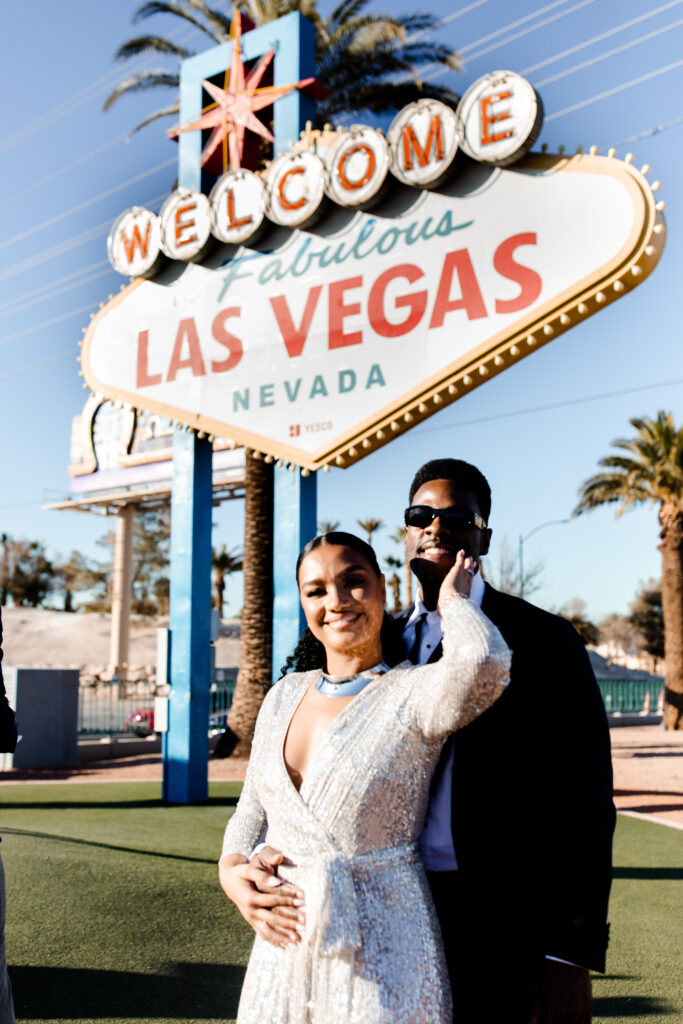 Bride and groom posing in front of the Welcome to Fabulous Las Vegas sign