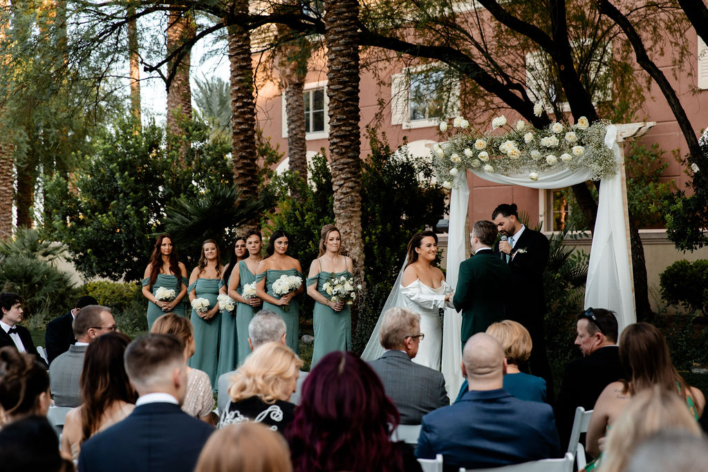 Bride and groom standing at the altar during their JW Marriott Las Vegas wedding ceremony on the lawn