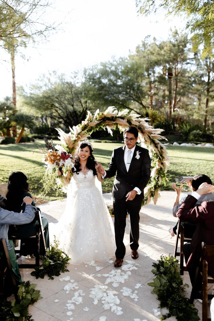 Bride and groom walking back down the aisle after their JW Marriot elopement ceremony in Las Vegas