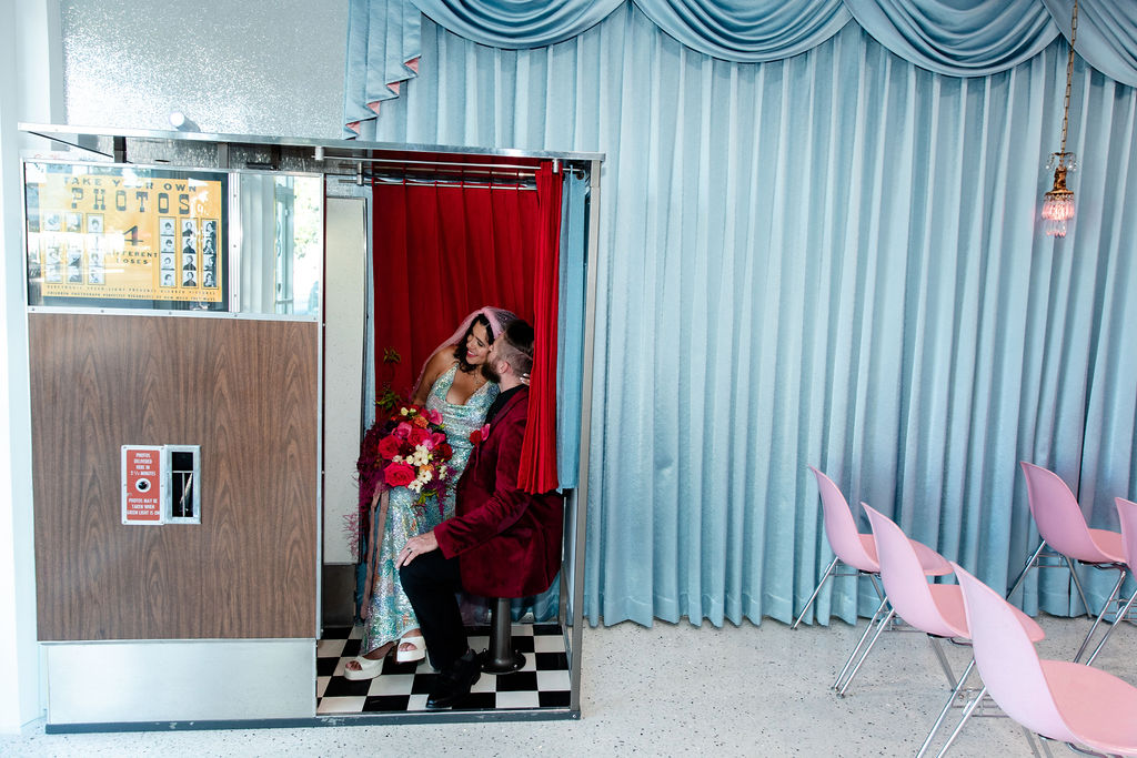 Bride and groom taking photos in the vintage analog photobooth at Sure Thing Chapel Too